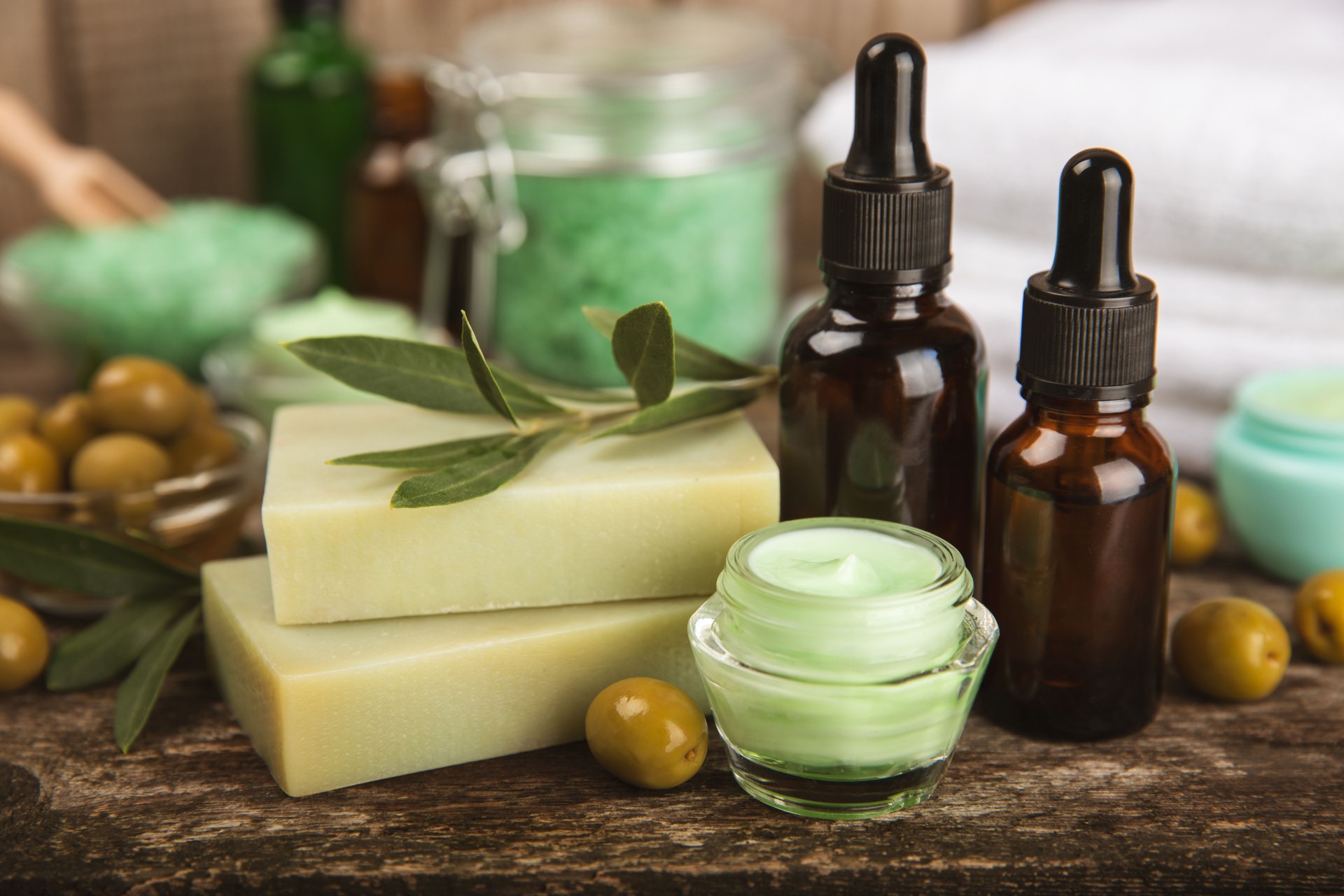 Olive Spa. Essential oils, face and body cream, scrub, sea salt, handmade soap with olive oil extract. Natural cosmetic. Beauty concept. Cosmetic tube. Space for text.Copy space