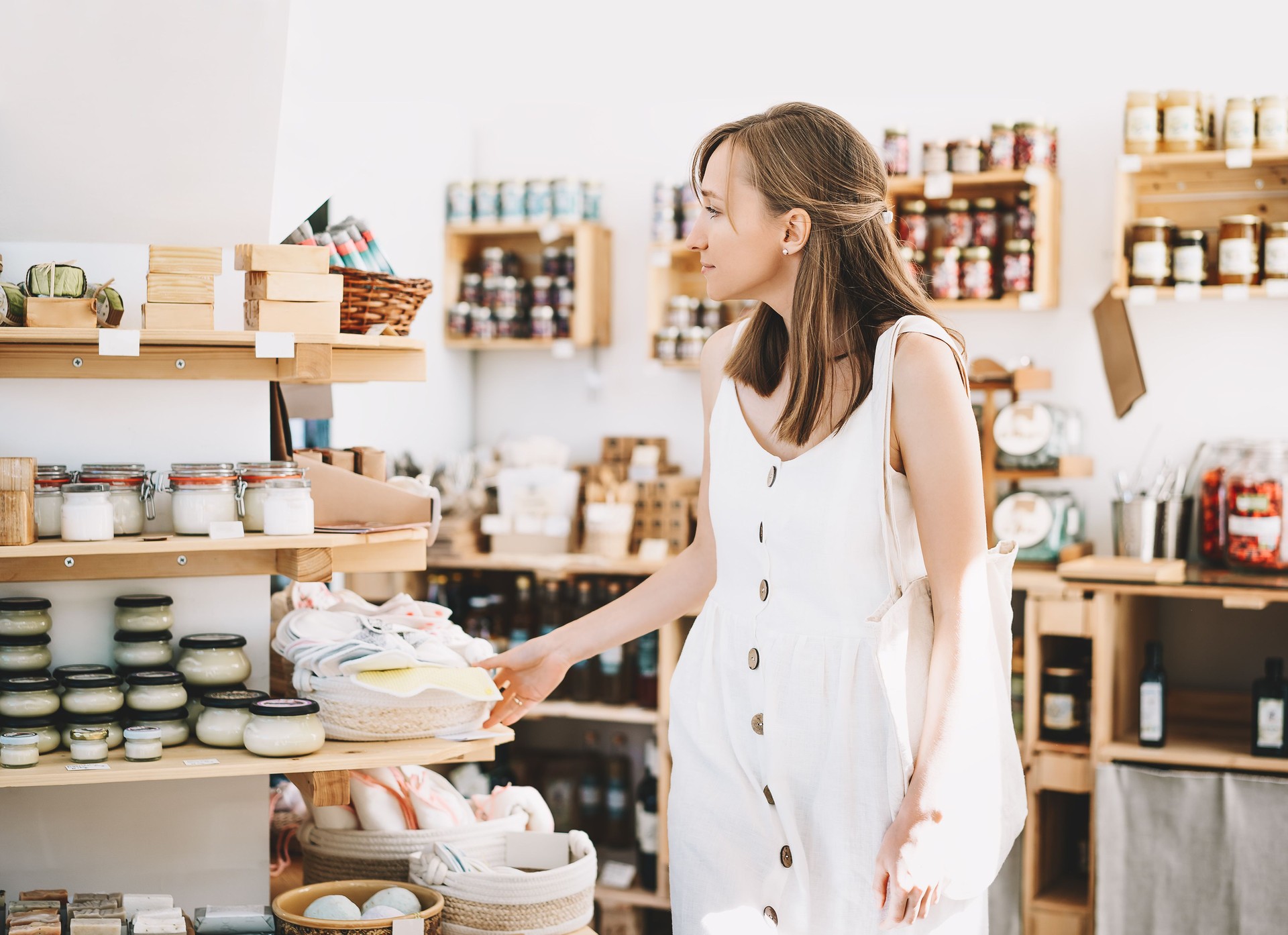 Woman with cotton bag buying personal hygiene items in zero waste shop. Eco Organic Cosmetics.